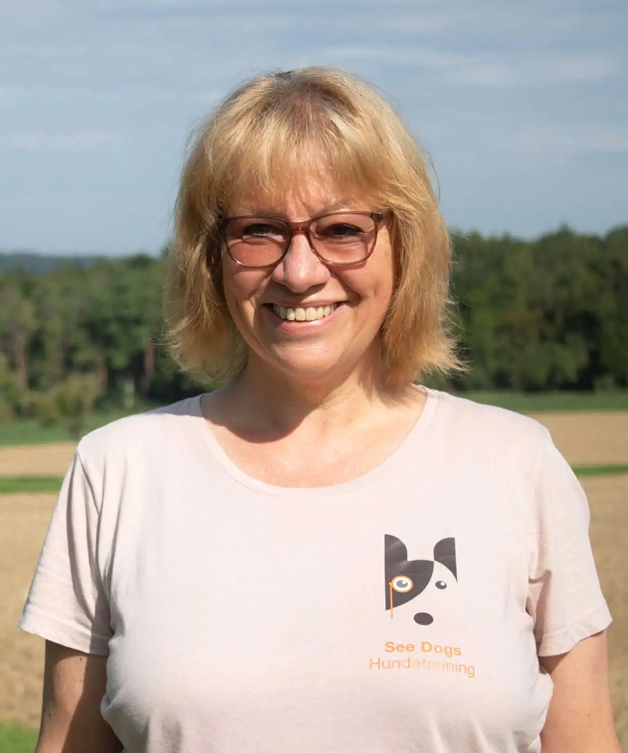 Frau (Alexandra Lutz) auf dem Feld mit einem Shirt von ihrer Hundeschule See Dogs